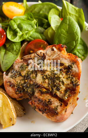 Grandi braciole di maiale alla griglia con basilico Condimento al limone Foto Stock