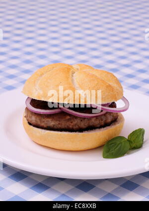 Il tedesco Hamburger sulla piastra, bianco e blu tovaglie a scacchi Foto Stock