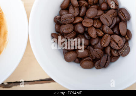 Caffè espresso italiano caffè e fagioli su un bianco tavola di legno Foto Stock