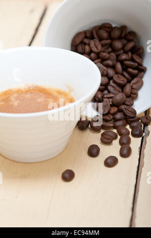 Caffè espresso italiano caffè e fagioli su un bianco tavola di legno Foto Stock