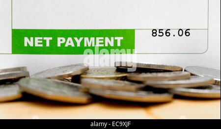 Pagamento netto su una busta paga con monete Inghilterra REGNO UNITO Foto Stock