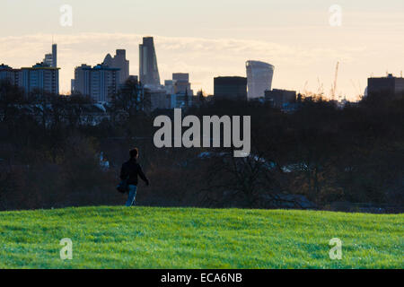 Londra, Regno Unito. 11 dicembre, 2014. Regno Unito Meteo: un " commuter " passeggiate a lavorare come dawn breaks oltre l'orizzonte di Londra. Credito: Paolo Davey/Alamy Live News Foto Stock