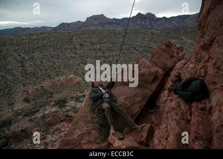 Giovane uomo belays uno scalatore al Red Rocks in Las Vegas NV. Foto Stock