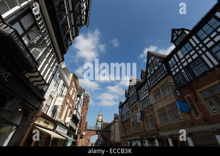 Città di Chester, Inghilterra. Il pittoresco angolo di visualizzazione dei negozi su Eastgate Street, con l'Eastgate Clock in background. Foto Stock