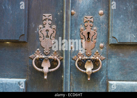 Vecchia serratura con due maniglie su una vecchia porta di legno Foto Stock