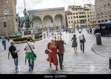 Vista verso sud attraverso affollato Piazza della Signoria con il Palazzo Vecchio e Statua equestre in bronzo di Cosimo de' Medici a sinistra Foto Stock