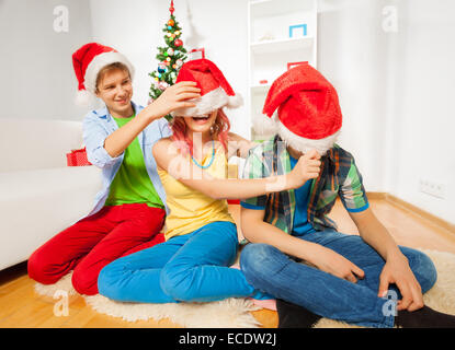 Tirare verso il basso il cappelli di Babbo Natale Foto Stock