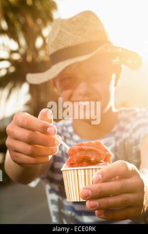 l'adolescente in vacanza al tramonto mangia gelato in estate Foto Stock