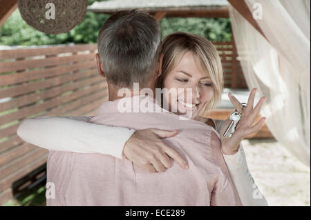 Coppia sposata Donna abbraccia tenendo premuto i tasti sorridente Foto Stock