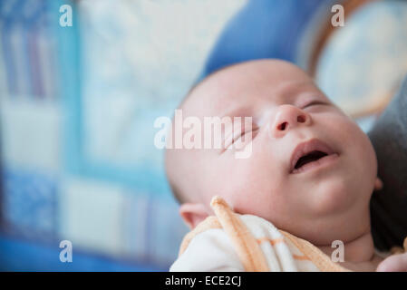 Baby boy dormire nelle braccia del padre, close up Foto Stock