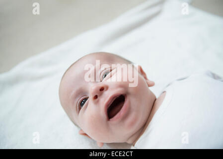 Bambino giacente sul letto, sorridente Foto Stock