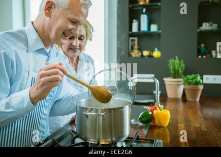 Coppia matura la preparazione di cibo in cucina, sorridente Foto Stock