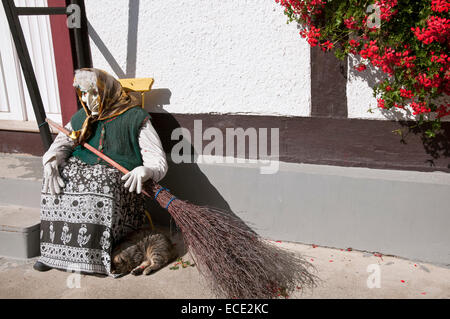 Tipico harzer witch bambola nella parte anteriore del vecchio legno incorniciata edifici, Germania Foto Stock