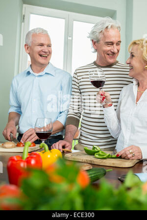 Alti uomini donna cucina prepara la cena a parlare Foto Stock