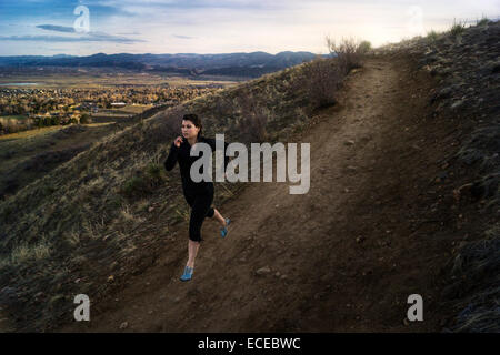 Stati Uniti d'America, Colorado, Jeferson County, Golden, donna in corsa lungo la collina strada di terra Foto Stock