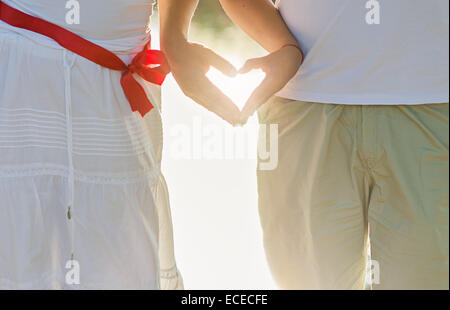 Le mani di due persone che fanno la forma del cuore Foto Stock