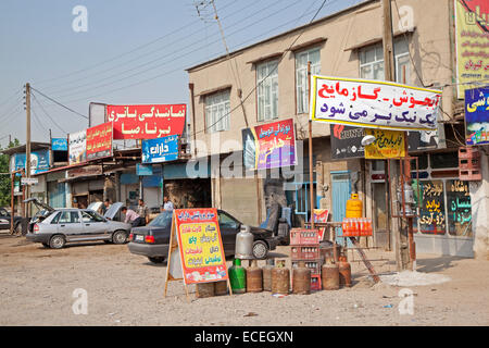 Iraniani lavorando su auto nel garage del primitivo, nelle officine di riparazione e un negozio di generi alimentari in villaggio in Iran Foto Stock