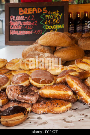 Pane e cereali integrali, pianura, ciambella, al mercato di Natale. specialità di pane per la vendita, con prezzi, Southport, Merseyside, Regno Unito Foto Stock