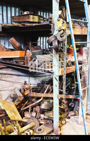 Magazzino di fabbrica con pezzi di ricambio usati in officina meccanica Foto Stock