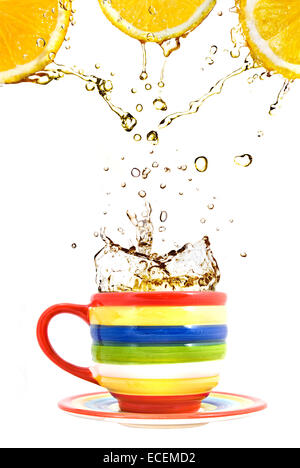 Tre limoni, colore cup e splash di tè isolato su bianco Foto Stock