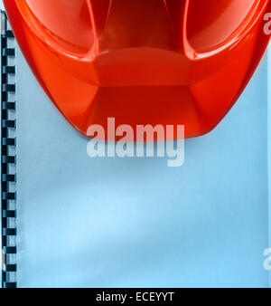 Casco rosso su bianco notebook Foto Stock