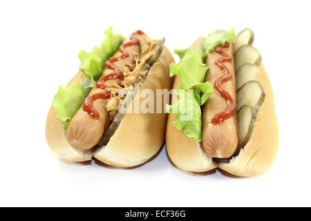 Hot Dogs con il cetriolo, salsiccia, cipolle fritte e ketchup Foto Stock