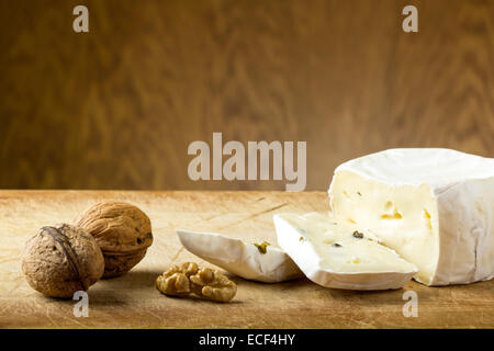 Close-up di formaggio e noci su uno sfondo di legno Foto Stock