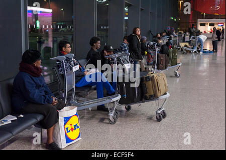 Londra, UK, 12 dicembre 2014. Un difetto nel software del Regno Unito il centro di controllo del traffico aereo si ferma temporaneamente il traffico aereo in spazio aereo del Regno Unito risultante in ritardi e cancellazioni dei voli per molti all'aeroporto di Heathrow. Nella foto : i passeggeri attendono lo status dei loro voli. Credito: Stephen Chung/Alamy Live News Foto Stock