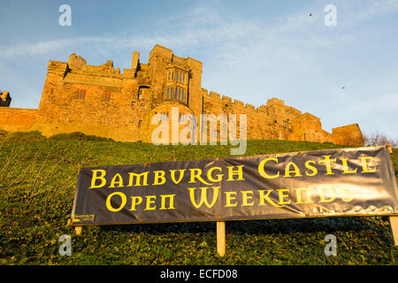 Il castello di Bamburgh, Northumberland, Regno Unito, nella luce incandescente al tramonto. Foto Stock