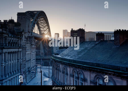 Il Quayside a Newcastle upon Tyne e Gateshead fotografato come il sole sorge dietro il Tyne Bridge durante la mattina. Foto Stock
