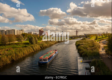 Barca sul fiume Lea con la città di Stratford e lo Stadio Olimpico in background. Foto Stock