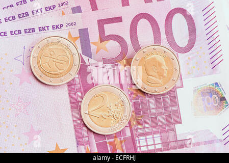 Monete metalliche in euro su un centinaio di banconote in euro sfondo. Foto Stock