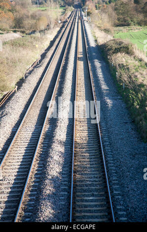 Elevato angolo consente di visualizzare due linee ferroviarie andando fuori in lontananza sulla costa ovest mainline a Woodborough, Wiltshire, Inghilterra, Regno Unito Foto Stock