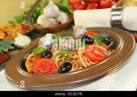 Un piatto di pasta, olive, pomodori, acciughe e capperi Foto Stock
