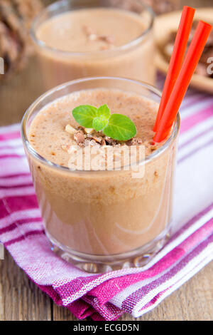 (Frullato al cioccolato e frullato di banana) in vetro con la menta e i dadi, caseificio artigianale colazione o verticale da dessert Foto Stock