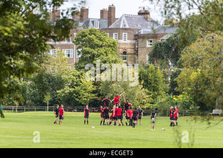 Ragazzi giocando a rugby presso il Magdalen College di campi da gioco, Oxford, Regno Unito Foto Stock