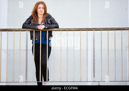 Un moody triste solo redhead zenzero pelose donna giovane ragazza adolescente da solo da se stessa appoggiato su di un balcone al di fuori di un abbandono abbandonati blocco di appartamenti REGNO UNITO Foto Stock