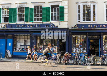 Un ciclista passa Blackwell bookshop, un famoso bookshop che servono la città e università di Oxford si trova su Broad Street, Oxford Foto Stock