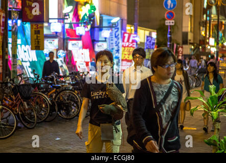 La gente che camminava per strada di Dotonbori dopo il lavoro notturno di Osaka. Foto Stock