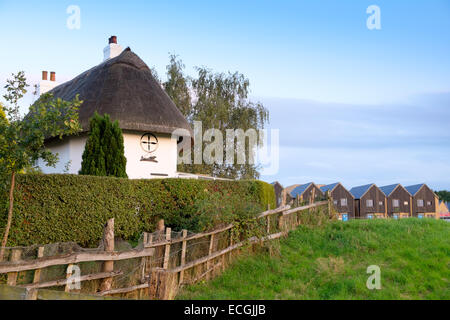 Il vecchio tetto di paglia cottage giustapposti contro un nuovo alloggiamento estate in Harlow Essex Inghilterra Foto Stock