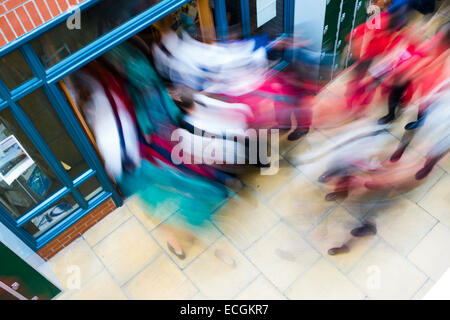 L'istruzione secondaria, Wales UK - Movimento immagine sfocata di una folla di allievi streaming fragore impetuoso in esecuzione al di fuori delle scuole di andare a casa alla fine della giornata di scuola Foto Stock