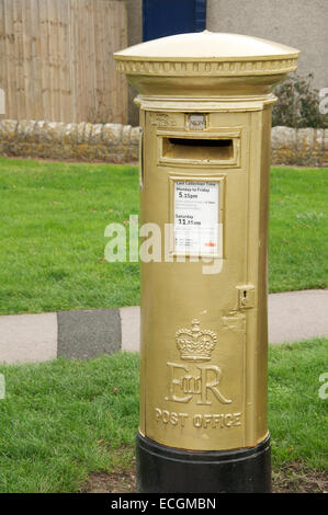 Golden postbox. Royal Mail pilastro scatola dipinta in oro e dedicato a Helena Lucas, un 2012 Paralimpico campione di vela. Isola di Portland, Dorset, Regno Unito. Foto Stock