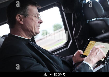 Gerusalemme, Israele. Il 14 dicembre, 2014. Padre EAMON Kelly, Vice responsabile del Pontificio Istituto Notre Dame di Gerusalemme, centro di leggere la sua preghiera di mezzogiorno su un iPad mentre cavalcate un bus. Credito: Nir Alon/Alamy Live News Foto Stock