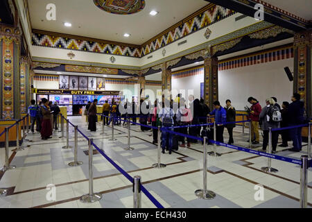 Passeggeri che passano attraverso i banchi immigrazione nella sala degli arrivi dell'aeroporto internazionale nella città di Paro in Bhutan Foto Stock