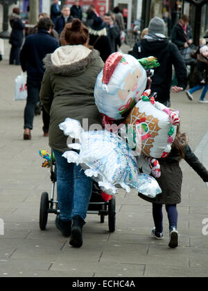 Wimbledon Londra,UK. Il 15 dicembre 2014. Una madre a fare shopping con un bambino spinge una carrozzina con palloncini di Natale Credit: amer ghazzal/Alamy Live News Foto Stock