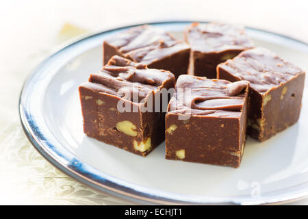 Fudge fatti in casa con i dadi e disposti su una piastra piccola. Foto Stock