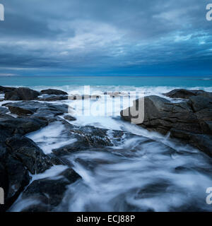 Onde infrangersi contro le coste rocciose a Skagsanden beach, Flakstad, Flakstadøy, Isole Lofoten in Norvegia Foto Stock