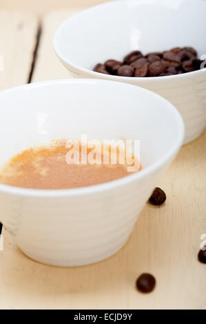 Caffè espresso italiano caffè e fagioli su un bianco tavola di legno Foto Stock