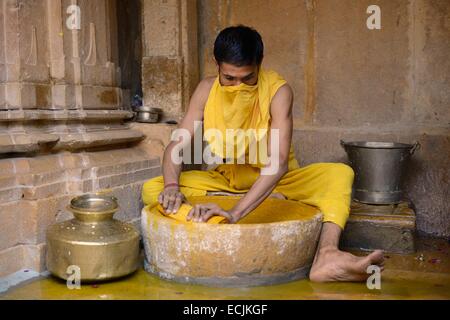 India Rajasthan, Jaisalmer, Shantinath tempio Jain sacerdote la preparazione di pasta di legno di sandalo per il culto della Tirthankaras o creatori di Ford Foto Stock