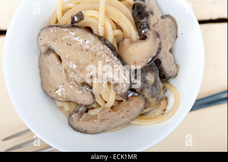 Italiano gli spaghetti e i funghi selvatici freschi sulla tavola in legno rustico Foto Stock